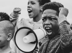 a group of young people shouting into a megaphone