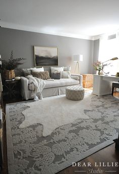 a living room with a large rug on the floor and a couch in front of it