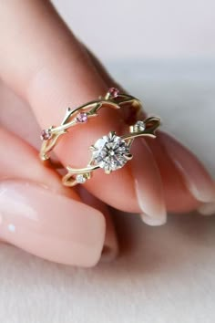 a woman's hand with a gold ring on it and a diamond in the middle