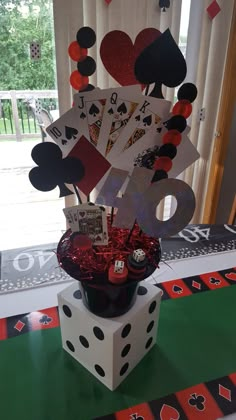 a card table with dices and cards on it in front of a window,