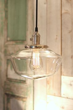 an old fashioned light fixture hanging from a ceiling in front of a wooden paneled wall