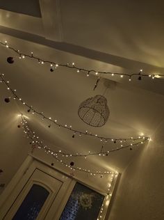 some lights are hanging from the ceiling in a room with a white door and window