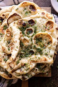 several flat bread pizzas on a wooden cutting board