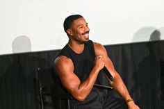 a man sitting in a chair holding a microphone