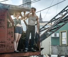 a man and woman standing on the back of a truck