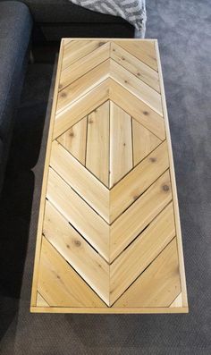 a wooden coffee table sitting on top of a carpeted floor next to a couch