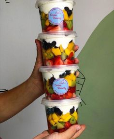 three plastic cups filled with fruit and yogurt sitting on top of each other