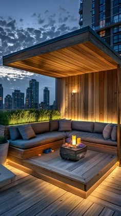 an outdoor living area with couches, tables and lights on the deck at night