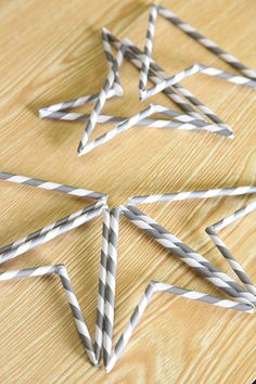 several silver and white striped straws on a wooden table