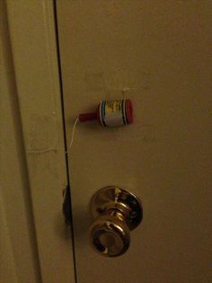 an open door with a toothbrush hanging on it's side and a tube of toothpaste stuck to the handle