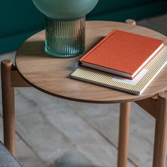 a table with two books and a vase on it