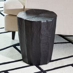 a black table sitting on top of a white rug next to a chair and couch