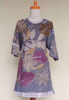 a dress on a mannequin with flowers and leaves painted on the front side