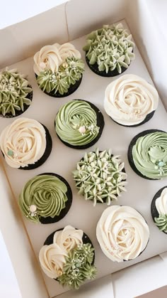 twelve cupcakes in a box decorated with green and white frosting, on top of each other