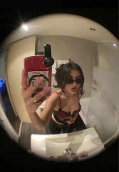 a woman is taking a selfie in the mirror with her cell phone and wearing sunglasses