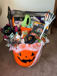 a basket filled with halloween items on top of a carpeted floor next to a wall