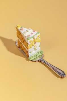 a piece of cake sitting on top of a spatula next to a yellow background