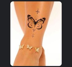 a butterfly tattoo on the side of a woman's leg with gold bracelets