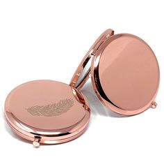 a compact mirror with a leaf design on it