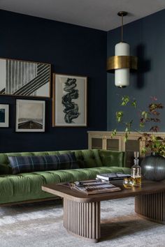 a living room with green couches and pictures on the wall above it, along with other furniture