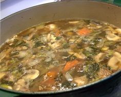 a pot filled with soup sitting on top of a stove next to a green counter