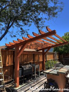 an outdoor kitchen is built into the side of a wooden building with a grill on it