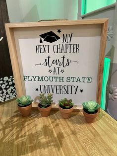 a sign that says my next charter starts at plymouth state university with three succulents in front of it