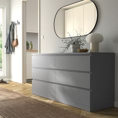 a white dresser sitting next to a large mirror