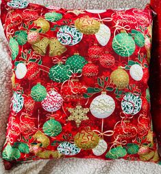 a red pillow with christmas decorations on it