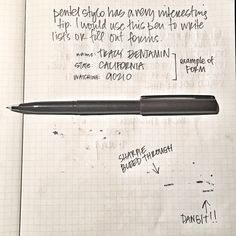 a pen sitting on top of a piece of paper next to a notepad with writing