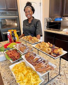 a woman standing in front of some trays of food