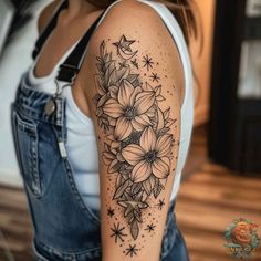 a woman with a black and white tattoo on her arm, showing the flower arrangement