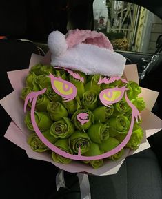 a bouquet of flowers with a face drawn on the side and a santa hat on top