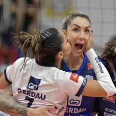 two female volleyball players are hugging each other