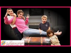 three children are posing for the camera in front of a trunk with their hands up