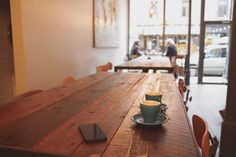 a cup of coffee sitting on top of a wooden table