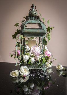 there is a lantern with flowers in it and the words above it are also english