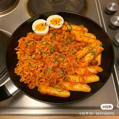 an egg sits on top of noodles in a skillet