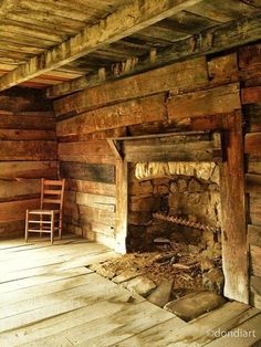 an old log cabin with a fireplace and rocking chair in the corner on the floor