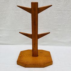 a wooden stand with three intersecting sections on each side and one in the middle, against a white background