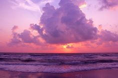 the sun is setting over the ocean with clouds