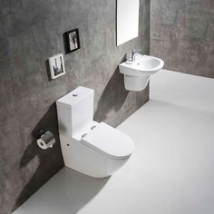 a white toilet sitting next to a bidet in a bathroom under a mirror on the wall