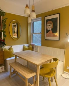 a dining room table with two yellow chairs and a bench in front of a window