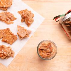 peanut butter cookies in a glass jar next to a jar of peanut butter on a wooden table