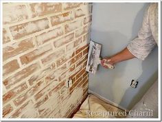 a person is painting a brick wall with paint rollers in the process of remodeling