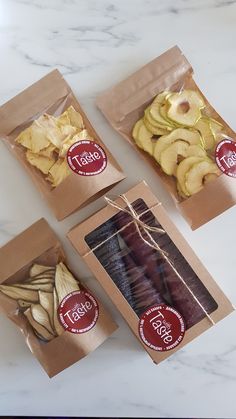 four bags of food sitting on top of a white marble counter next to each other