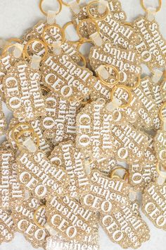 lots of gold and white glittered cookies with words on them