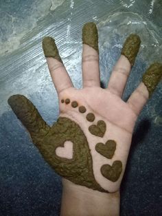 a person's hand painted with green and white hearts