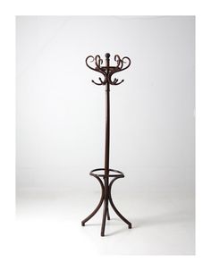 an iron coat rack with three candles on it