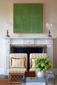 a living room filled with furniture and a painting on the wall